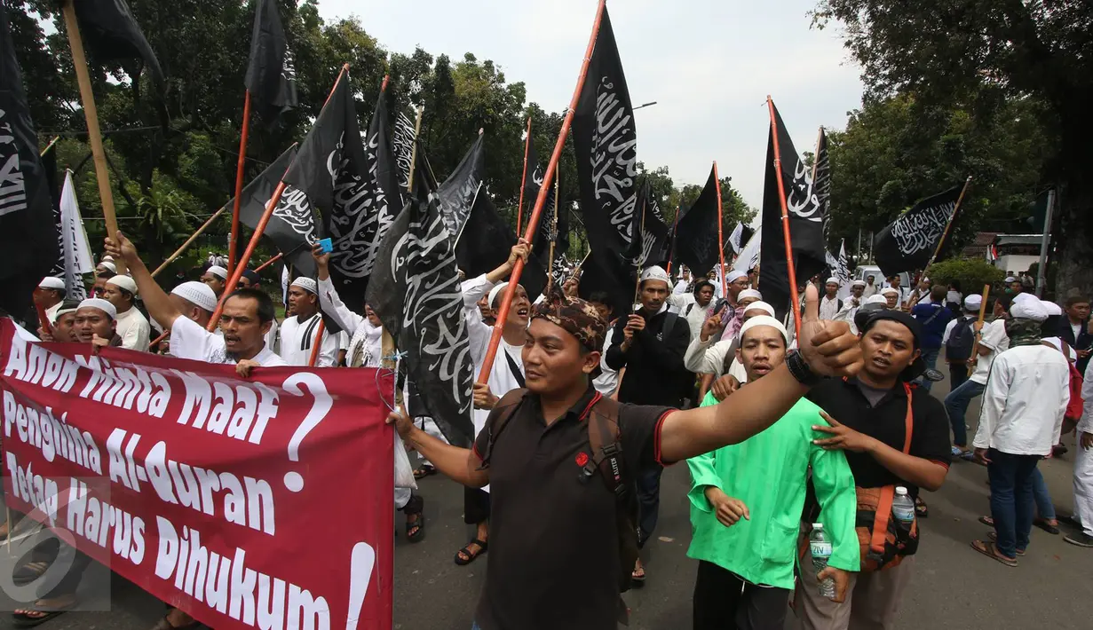 Massa membawa bendera dan spanduk saat melintas di Jalan Medan Merdeka Selatan, Jakarta, (4/11). Dalam aksinya, massa menuntut agar polisi segera menangkap Gubernur Nonaktif Basuki T Purnama atas dugaan penistaan agama. (Liputan6.com/Immanuel Antonius)