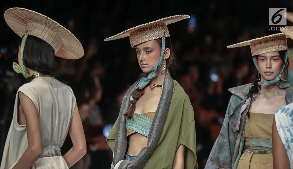 Model memperagakan busana rancangan HUMBANG SHIBORI x PURANA saat Jakarta Fashion Week 2019 di Senayan City, Jakarta, Kamis (25/10). Tenun ikat Humbang Shibori merupakan kerajinan kriya yang dibuat dengan metode ikat celup. (Liputan6.com/Faizal Fanani)