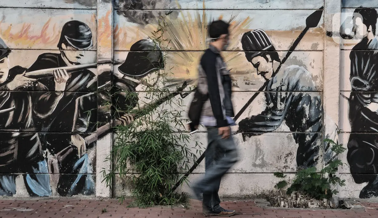 Pejalan kaki melintasi mural bertemakan Perjuangan Kemerdekaan Republik Indonesia di Jalan Pluit Raya III, Jakarta, Senin (10/8/2020). Mural itu diharapkan menjadi media agar masyarakat mengingat sejarah dan menghargai jasa para pahlawan dalam memerdekakan Tanah Air. (merdeka.com/Iqbal Nugroho)