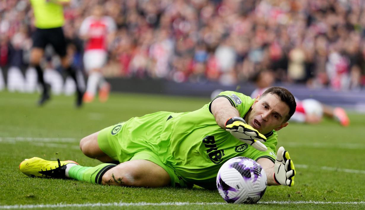 Kiper Aston Villa, Emiliano Martinez berhasil mengamankan bola dari ancaman pemain Arsenal pada laga pekan ke-33 Premier League 2023/2024 di Emirates Stadium, London, Minggu (14/4/2024). (AP Photo/Kirsty Wigglesworth)
