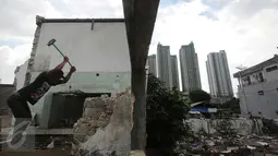 Pekerja membongkar rumah di kawasan padat penduduk Kebon Melati, Jakarta, Selasa (9/2). Hal ini dilakukan warga karena mulai terdesak dengan meningkatnya pembangunan gedung bertingkat di pusat kota. (Liputan6.com/Angga Yuniar)