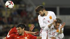 Pemain Spanyol, Gerard Pique menghalau bola dari kejaran pemain Makedonia pada laga kualifikasi Piala Dunia 2018 grup G di Philip II National Stadium, Skopje, MaKedonia, (11/6/2017). (AP/Boris Grdanoski)