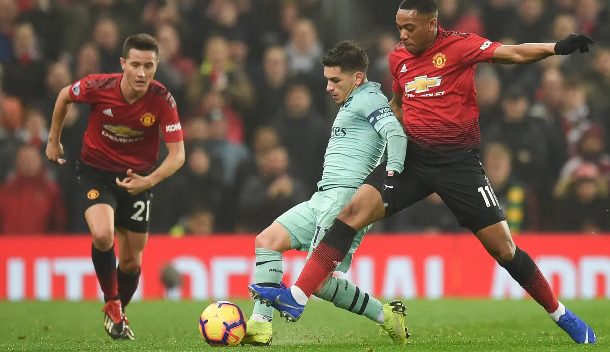 Gelandang Arsenal, Lucas Torreira menggiring bola dari kawalan striker Manchester United, Anthony Martial selama pertandingan lanjutan Liga Inggris di stadion Old Trafford (5/12). MU bermain imbang 2-2 atas Arsenal. (AFP Photo/Oli Scarff)