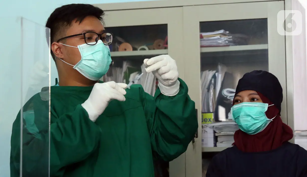 Vaksinator menyiapkan vaksin COVID-19 sebelum disuntikkan ke tenaga kesehatan yang bertugas di Puskesmas Jurang Mangu, Tangerang Selatan, Jumat (15/1/2021). Program vaksinasi COVID-19 tahap pertama kepada tenaga kesehatan mulai dilakukan di berbagai daerah di Indonesia. (Liputan6.com/Angga Yuniar)