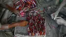 Pekerja memasukan sumbu untuk membuat petasan yang digunakan dalam festival Diwali di Ahmadabad, India (27/9). Menjelang perayaan Diwali, sejumlah produsen petasan di India dibanjiri pesanan. (AP Photo/Ajit Solanki)