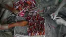 Pekerja memasukan sumbu untuk membuat petasan yang digunakan dalam festival Diwali di Ahmadabad, India (27/9). Menjelang perayaan Diwali, sejumlah produsen petasan di India dibanjiri pesanan. (AP Photo/Ajit Solanki)