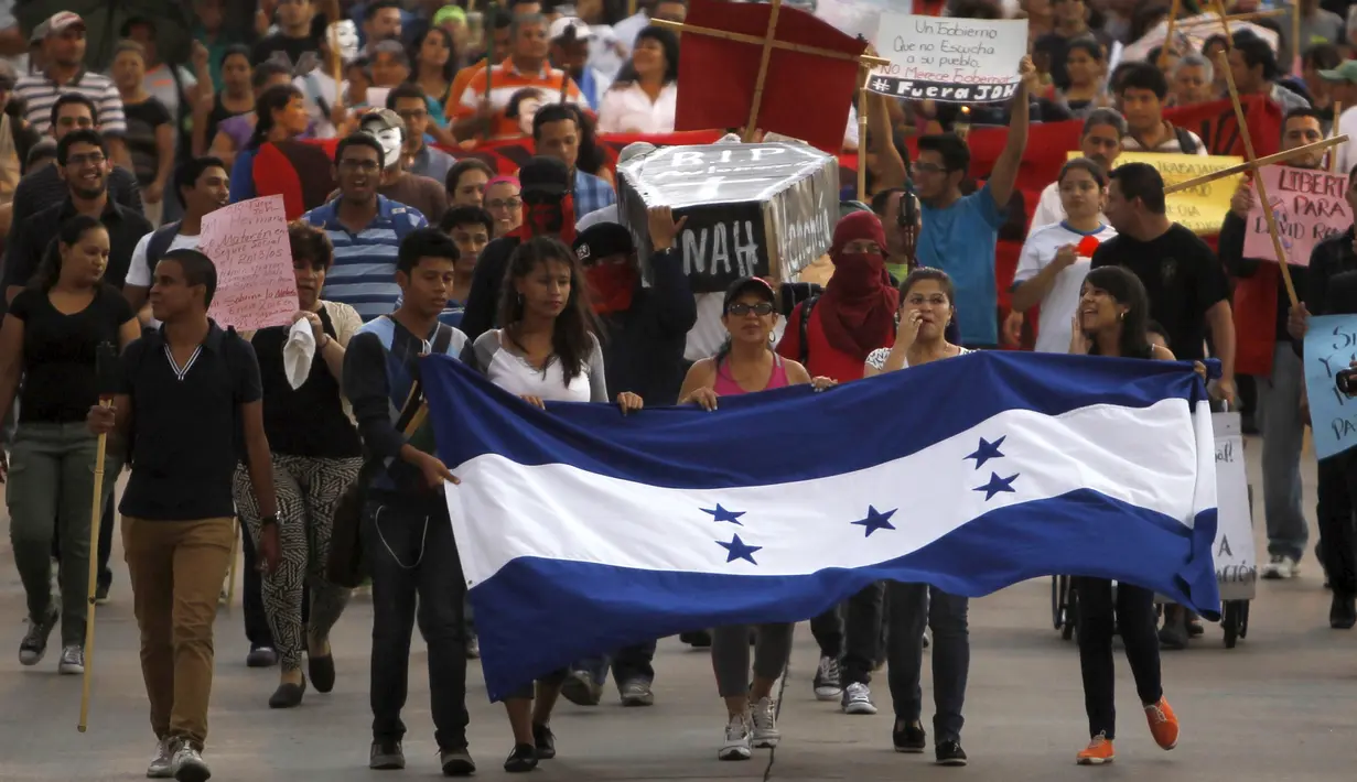 Ribuan demonstran turun ke jalan menuntut pengunduran diri Presiden Honduras, Juan Orlando Hernandez di Tegucigalpa, Jumat (24/7/2015).  Massa menuntut Presiden Juan Hernandez turun atas dugaan korupsi. (REUTERS/Jorge Cabrera)