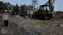 Petugas kepolisian mengamati lokasi jatuhnya pesawat Hercules C-130, di Jalan Jamin Ginting, Medan, Sumut, Kamis (2/7/2015). Untuk mensterilisasi lokasi, petugas memasang barikade kawat berduri. (Liputan6.com/Johan Tallo)