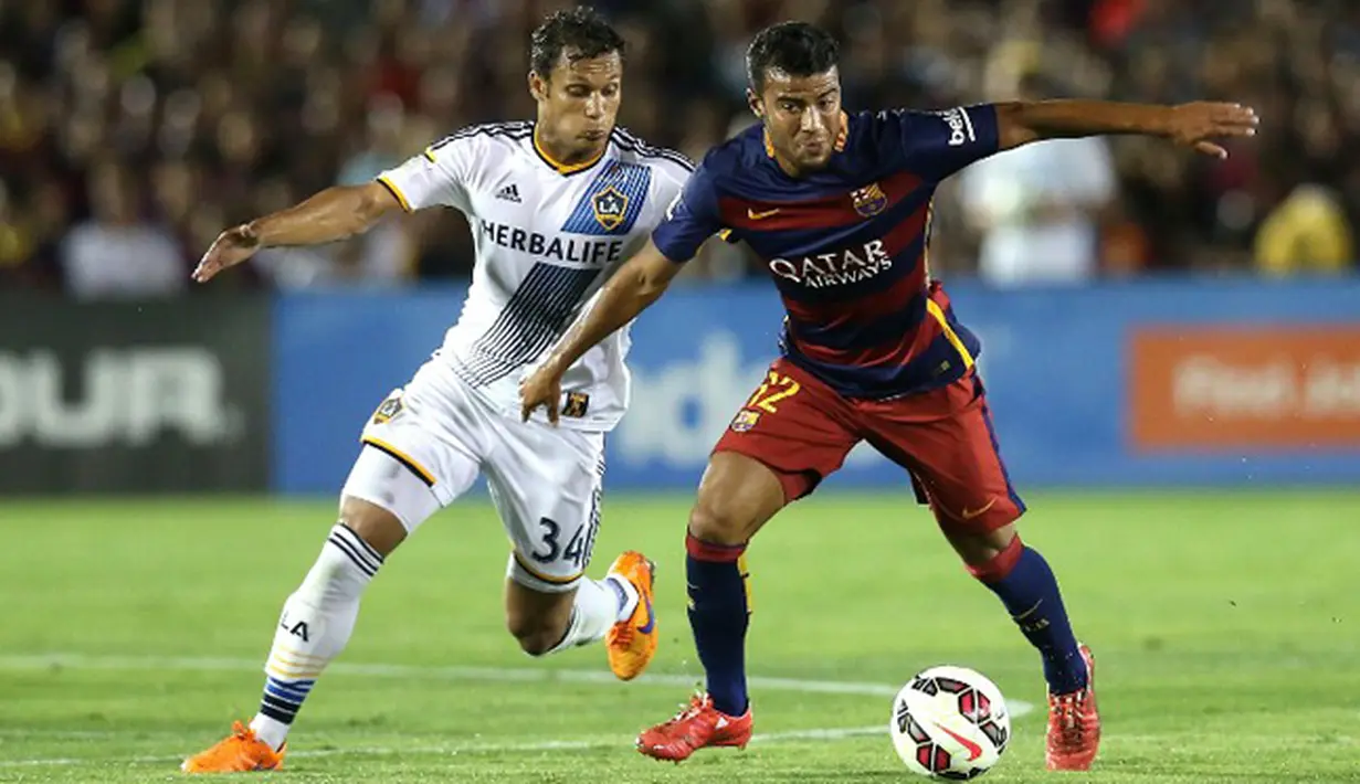Gelandang LA Galaxy, Kenney Walker (kiri) berusaha merebut bola yang dibawa gelandang Barcelona, Rafinha pada laga International Champions Cup 2015 di Rose Bowl, California, Rabu (22/7/2015). Barcelona menang 2-1 atas LA Galaxy. (AFP PHOTO/Stephen Dunn)