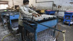 Seorang pekerja membuat lilin jelang Festival Cahaya Diwali di sebuah pabrik pinggiran Ahmedabad, India, 4 November 2020. (SAM PANTHAKY/AFP)