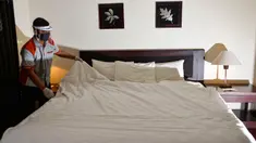 Seorang pekerja dengan mengenakan alat pelindung mempersiapkan sebuah kamar di sebuah hotel yang dibuka kembali setelah ditutup selama tiga bulan akibat pandemi COVID-19 di Banda Aceh pada Rabu (15/7/2020). (Photo by CHAIDEER MAHYUDDIN / AFP)