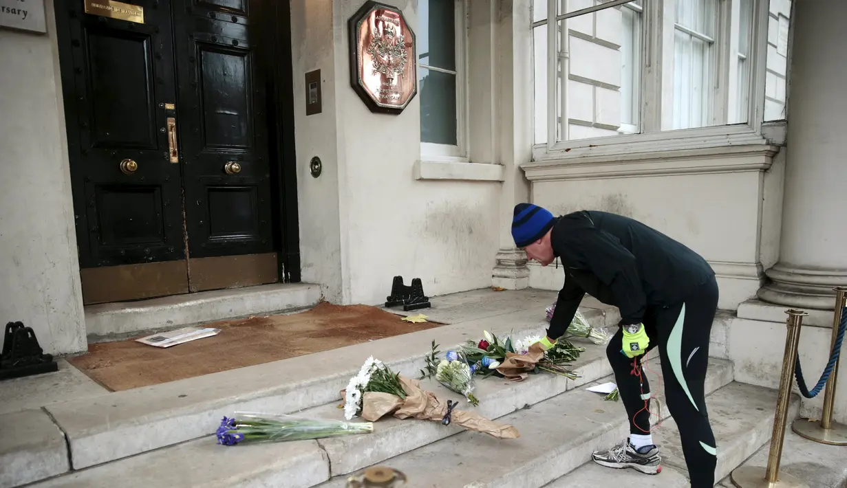 Seorang pria menaruh bunga di luar kedutaan Perancis sebagai penghormatan kepada korban serangan Paris, di London, Inggris (14/11/2015). Serangan teroris yang terjadi di Paris telah menewaskan sekitar 140 orang. (REUTERS/Suzanne Plunkett)