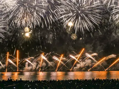 Orang-orang berkumpul untuk menonton kembang api pada Hari Bastille di sebuah pantai di Cannes, Prancis, Rabu (14/7/2021). Prancis merayakan Hari Bastille dengan ribuan tentara berbaris dalam parade Paris, setelah acara tahun lalu dikurangi karena ketakutan akan COVID-19. (AP Photo/Vadim Ghirda)