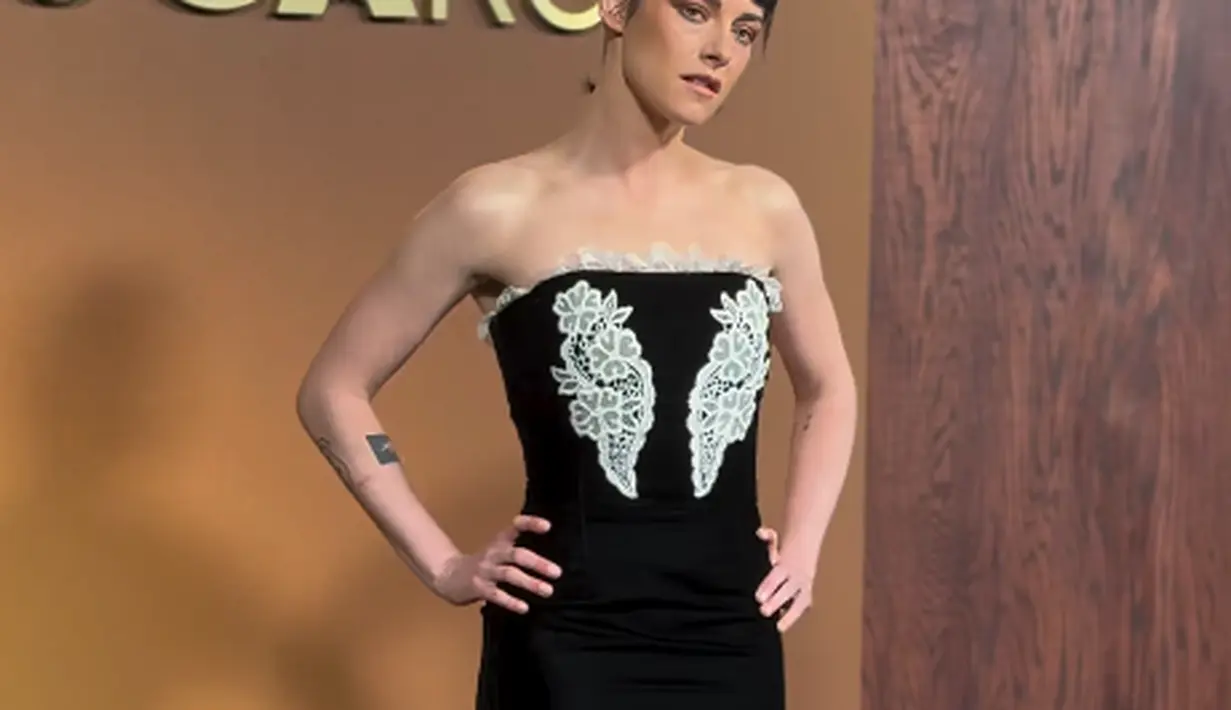 Kristen Steward tampil fierce dengan strapless dress hitam beraksen lace di bagian neckline. Motif laced wing hiasi dress polosnya [@theacademy]