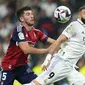 Bek Osasuna David Garcia berebut bola dengan penyerang Real Madrid Karim Benzema  pada pekan ketujuh Liga Spanyol 2022/2023 di Stadion Santiago Bernabeu, Senin dini hari WIB (3/10/2022). Dengan hasil ini, Real Madrid memang masih menjaga rekor tak terkalahkan, tapi mereka gagal menyalip Barcelona. (AP Photo/Manu Fernandez)