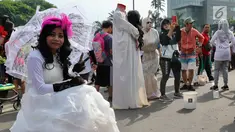 Seniman dengan kostum none Belanda berpose saat kegiatan Car Free Day di Bundaran HI di Jakarta, Minggu, (12/11). Mereka membuka kesempatan kepada warga yang ingin foto bersama. (Liputan6.com/Fery Pradolo)