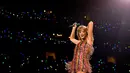 Di konser yang sama, Taylor Swift juga mengenakan bodysuit namun kali ini dengan garis warna-warni. Bodysuit bernuansa pink ini memiliki aksen fringes yang flowy.