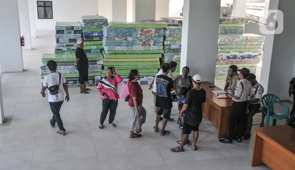 Petugas mendata warga korban kebakaran Pasar Gembrong saat direlokasi ke Rusun Cipinang Besar Utara, Jakarta Timur, Senin (23/5/2022). Sebanyak 500 jiwa dari 110 keluarga yang merupakan korban kebakaran Pasar Gembrong pada Minggu, 24 April 2022 malam lalu mulai direlokasi ke Rusun Cipinang Besar Utara. (merdeka.com/Iqbal S Nugroho)