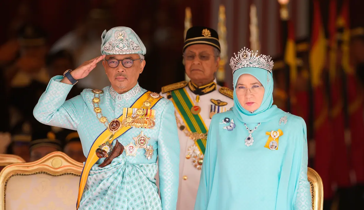 Raja Malaysia Sultan Abdullah Sultan Ahmad Shah (kiri) memberi hormat di samping Ratu Tunku Azizah Aminah Maimunah dan PM Mahathir Mohamad saat upacara pelantikannya di Istana Nasional, Kuala Lumpur, Malaysia, Kamis (31/1). (AP Photo/Yam G-Jun)