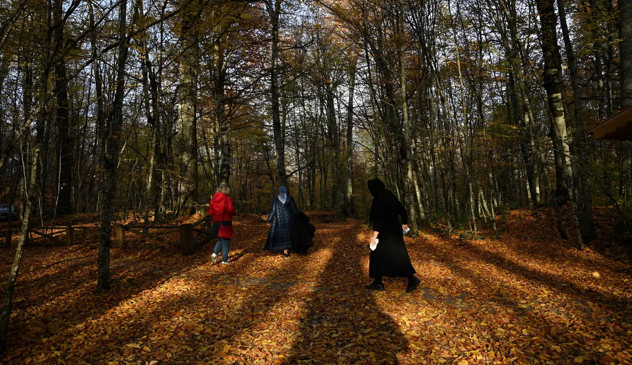 Orang-orang berjalan di Taman Nasional Yedigoller di distrik Bolu, pada 9 November 2021. Turki merupakan sebuah negara dengan tujuan wisata yang populer di musim gugur, diantaranya adalah Taman Nasional Yedigöller. (Ozan KOSE / AFP)