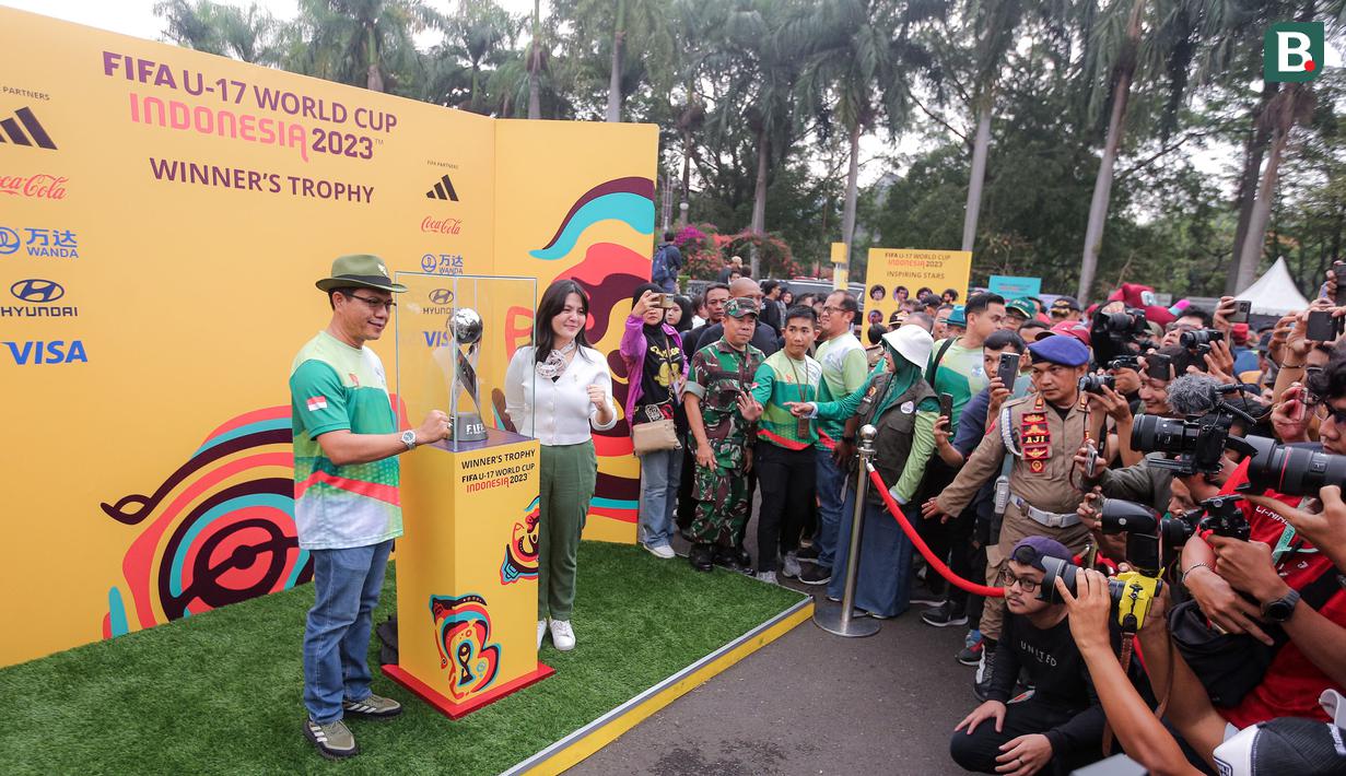 Bupati Kabupaten Bandung, Dadang Supriatna (kiri) didampingi waketum PSSI, Ratu Tisha Destria berfoto bersama trofi Piala Dunia U-17 dalam rangkaian acara Trophy Experience menyambut Piala Dunia U-17 2023 di Plaza Upakarti, Soreang, Kabupaten Bandung, Minggu (22/10/2023) sore WIB. (Bola.com/Bagaskara Lazuardi)