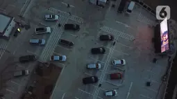 Foto dari udara menunjukkan deretan mobil penonton terparkir saat menyaksikan pemutaran film secara drive-in di Cikarang, Bekasi, Jawa Barat, Rabu (3/6/2020). Kehadiran drive-in cinema memberikan hiburan alternatif kepada warga di tengah pandemi virus corona COVID-19. (Liputan6.com/Herman Zakharia)