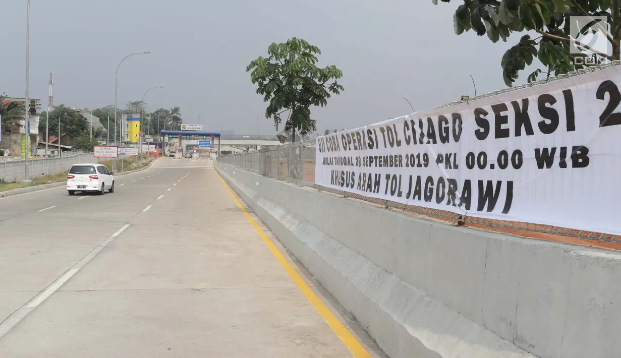 Spanduk uji coba operasi tol Cijago seksi 2 terpasang di Depok, Jawa Barat, Sabtu (28/9/2019). Gerbang tol Cijago seksi 2 (Jl Raya Bogor-Kukusan) sepanjang 5,5 km dapat dilalui secara fungsional mulai Sabtu (28/9) pukul 00.00 WIB. (Liputan6.com/Helmi Fithriansyah)