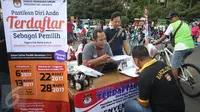 Seorang warga mengisi formulir pendaftaran di Pos Penyempurnaan Data dan Daftar Pemilih saat pelaksanaan Hari Bebas Kendaraan Bermotor (HBKB) di Jakarta, Minggu (12/3). (Liputan6.com/Immanuel Antonius)
