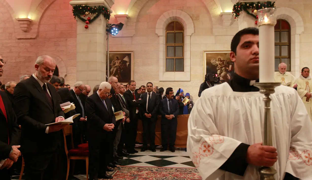 Presiden Palestina Mahmoud Abbas saat menghadiri misa Natal di Gereja Santa Katarina yang terhubung ke Gereja Nativity, di kota Bethlehem di Tepi Barat, (25/12). (AFP Photo/Musa Shaer Poll)