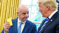 Presiden FIFA, Gianni Infantino menunjukkan kartu kuning kepada Presiden AS Donald Trump selama pertemuan di Oval Office Gedung Putih, Selasa (28/8). Presiden FIFA bertemu Trump untuk membahas kesiapan Piala Dunia 2026. (AFP/Mandel Ngan)