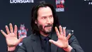 Aktor Keanu Reeves menunjukkan telapak tangannya yang masih berlumuran semen di halaman depan TCL Chinese Theatre, Los Angeles, Selasa (14/5/2019). Aktor 54 tahun itu mendapat penghargaan membuat cetakan tangan dan kaki untuk merayakan keberhasilan karirnya dalam film. (VALERIE MACON / AFP)