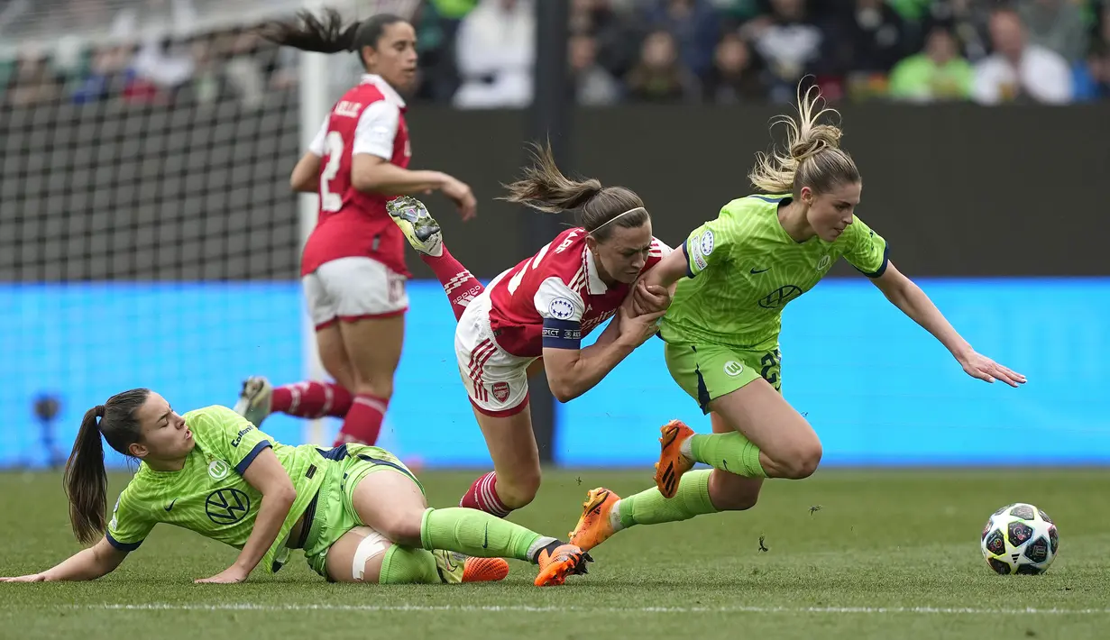 Pemain Arsenal, Katie McCabe (tengah) berebut bola dengan pemain Wolfsburg, Jule Brand (kanan) dan Lena Oberdorf pada laga leg pertama semifinal Liga Champions Wanita 2022/2023 di Volkswagen Arena, Wolfsburg, Jerman, Minggu (23/04/2023). Laga berakhir dengan skor 2-2. (AP Photo/Martin Meissner)