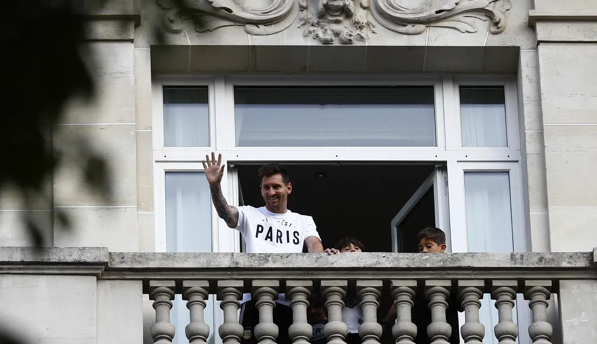 Megabintang Lionel Messi melambai kepada para fans dari balkon hotel Royal Monceau di Paris pada Selasa (10/8/2021). Mantan bintang Barcelona itu tiba di hotel setelah menjalani tes medis dan sempat ke Stadion Parc des Princes, kandang PSG (Paris Saint-Germain). (Sameer Al-DOUMY/AFP)