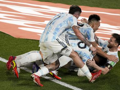 Rekan setimnya berselebrasi dengan penyerang Argentina, Lionel Messi setelah dia mencetak gol ke gawang Uruguay pada laga Kualifikasi Piala Dunia 2022 Zona Amerika Selatan di Monumental stadium, Senin (11/10/2021) pagi WIB. Argentina melibas Uruguay dengan skor 3-0. (AP Photo/Natacha Pisarenko)