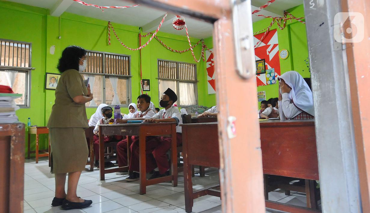 Siswa mengerjakan ujian penilaian akhir semester (PAS) yang dihadiri guru pengawas di SDN Pondok Cina 1 Depok, Jawa Barat, Senin (5/12/2022). Guru SDN Pondokcina 1 Depok kembali hadir di sekolah itu pada hari ini. (merdeka.com/Arie Basuki)