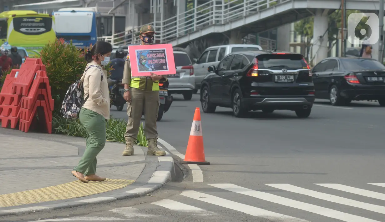 Petugas Satpol PP memegang poster himbauan kepada masyarakat tentang Covid-19, Jakarta, Jumat (6/11/2020). Upaya pemerintah tidak berhenti mengingatkan masyarakat untuk selalu mengenakan masker dan 3M agar terhindar dari bahaya penyebaran Covid-19 yang kini belum berakhir. (merdeka.com/Imam Buhori)