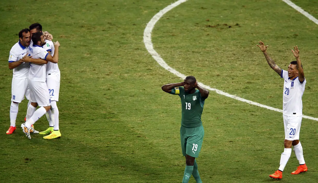 Kapten Timnas Pantai Gading, Yaya Toure (kedua dari kanan) berjalan lunglai usai dikalahkan Yunani 1-2 di Stadion Castelao, Fortaleza, Brasil, (25/6/2014). (REUTERS/Mike Blake)