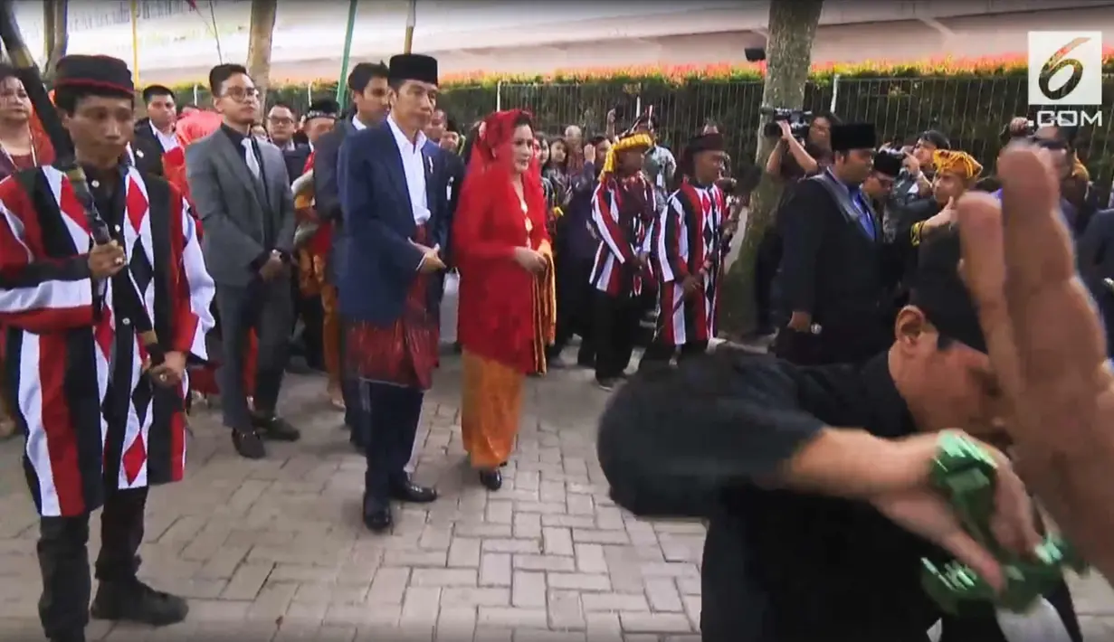 Presiden Joko Widodo dan Ibu Negara Iriana mendengarkan sambutan saat mengikuti prosesi penyambutan keluarga mempelai wanita secara adat di Bukit Hijau Regency Taman Setia Budi (BHR Tasbi), Medan, Sabtu (25/11). (Liputan6.com/vidio)
