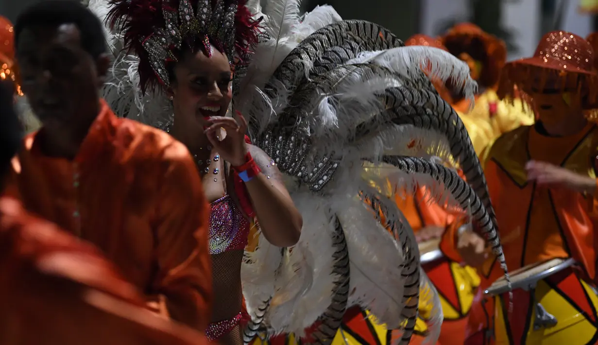 Anggota karnaval Uruguay, Comparsa, menari mengikuti irama musik selama parade karnaval Llamadas di Montevideo, Kamis (7/2). Karnaval terbesar di Uruguay ini menampilkan kelompok penari seksi dan musik tradisional selama dua hari. (PABLO PORCIUNCULA/AFP)