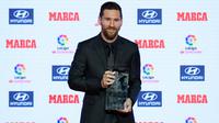 Megabintang Argentina, Lionel Messi menerima trofi Alfredo Di Stefano sebagai pemain terbaik LaLiga 2017-18 pada Football Marca Awards di Barcelona, Senin (12/11). Gelar pemain terbaik LaLiga kali ini merupakan yang ke-7 untuk Messi. (LLUIS GENE/AFP)