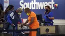 <p>Pelancong mengantre di loket tiket Southwest Airlines di Bandara Internasional Los Angeles, Senin (25/4/2022). Seminggu sebelumnya, seorang hakim federal di Florida menolak persyaratan untuk memakai masker di bandara dan selama penerbangan. Aturan itu, yang dirancang untuk membatasi penyebaran COVID-19, akan berakhir pada 3 Mei. (AP Photo/Marcio Jose Sanchez)</p>