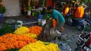 Seorang pedagang menjajakan bunga untuk dijual selama Festival Durga Puja di pinggir jalan Siliguri, India, Selasa (12/10/2021). Durga Puja juga disebut Durgotsab adalah festival tahunan di Asia Selatan untuk memuja dewi Durga dari agama Hindu. (DIPTENDU DUTTA/AFP)