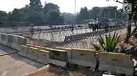 Pembatas beton dan kawat berduri menutup akses menuju Gedung DPR RI di Jalan Gatot Subroto, Jakarta, Kamis (26/9/2019). Pasca demonstrasi mahasiswa dan pelajar selama dua hari, Polisi menutup akses jalan mulai dari simpang Gerbang Pemuda. (merdeka.com/Iqbal S Nugoroho)