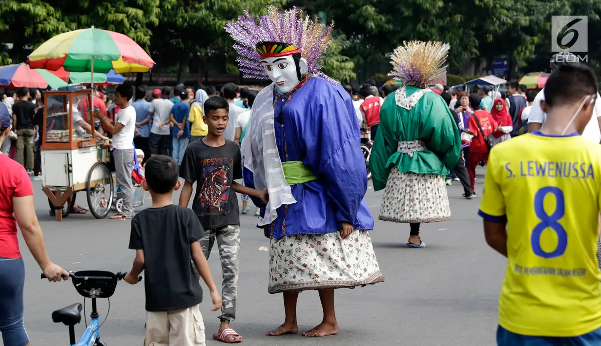 Pengamen ondel-ondel meminta sumbangan kepada warga di lokasi car free day, Jakarta, Minggu (21/5). Ramainya pengunjung CFD menyebabkan banyak pengamen mencari rezeki di kegiatan yang berlangsung setiap minggu tersebut. (Liputan6.com/Immanuel Antonius)