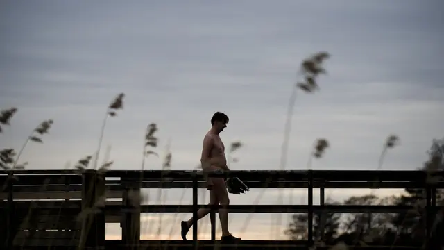 Seorang pria Finlandia keluar setelah berenang di danau yang dingin saat menghabiskan hari di sauna umum di Helsinki pada tanggal 15 April 2011. FOTO AFP / JONATHAN NACKSTRAND JONATHAN NACKSTRAND / AFP