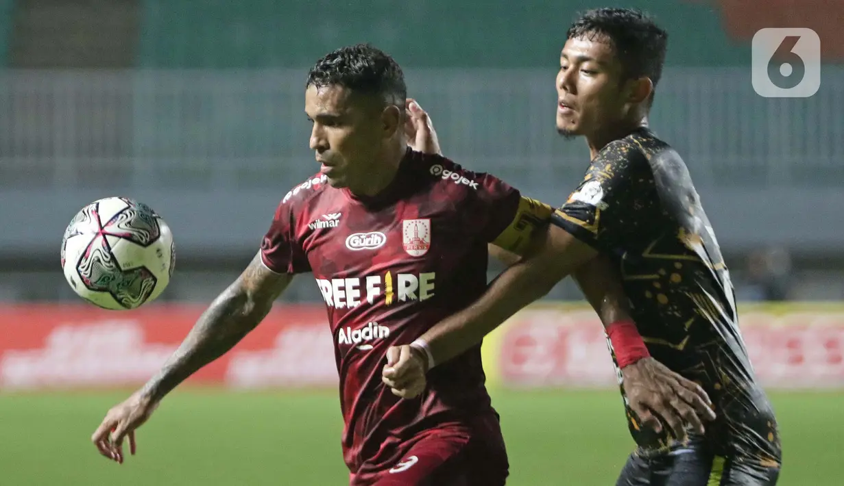Penyerang Persis Solo, Alberto Goncalves (kiri) berebut bola dengan pemain Rans Cilegon United, M Hamdan Zamzani pada laga Final Liga 2 Indonesia 2021 di Stadion Pakansari, Bogor, Kamis (30/12/2021). Persis Solo unggul 2-1. (Liputan6.com/Helmi Fithriansyah)