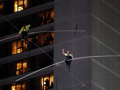 Aerialists Nik Wallenda (kanan) dan saudara perempuannya Lijana Wallenda melintasi seutas kawat di ketinggian 396 meter, Times Square, New York, AS, Minggu (23/6/2019). Aksi berbahaya ini bertajuk Highwire Live In Times Square. (AP Photo/Jason Szenes)