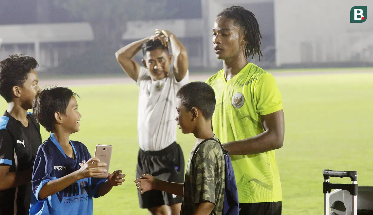 Fans cilik meminta izin untuk foto bersama dengan pemain Timnas Indonesia U-19, Ronaldo Kwateh usai melakukan latihan jelang Piala AFF U-19 2022 di Stadion Madya, Jakarta, Selasa (21/6/2022). (Bola.com/M Iqbal Ichsan)