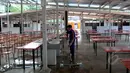 Seorang petugas tampak membersihkan area kios dari genangan air, Jakarta, Kamis (9/4/2015). Pemda DKI Jakarta telah menyeleksi 339 PKL yang akan menempati kios tersebut. (Liputan6.com/Johan Tallo)