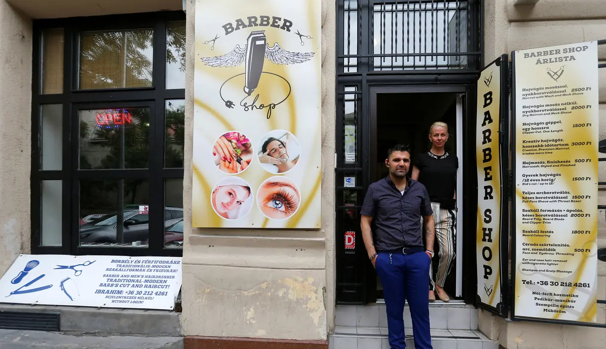 Ibrahim Haji Mohammad, seorang pengungsi Kurdi dari Suriah dan istrinya asal Hungaria Krisztina berdiri depan toko cukur miliknya di Budapest, Hongaria, 24 Mei 2016. (REUTERS / Laszlo Balogh)